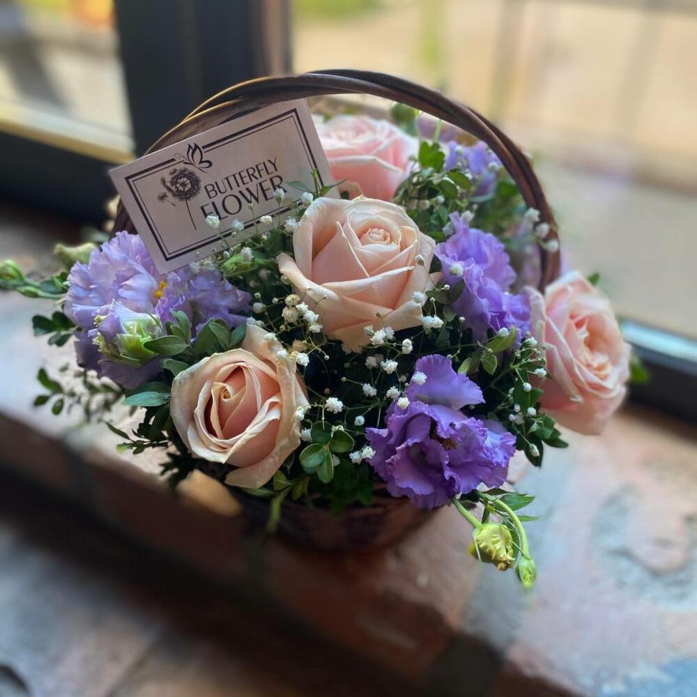 Букет из роз, эустомы, гипсофилы и самшита в плетеной корзине 