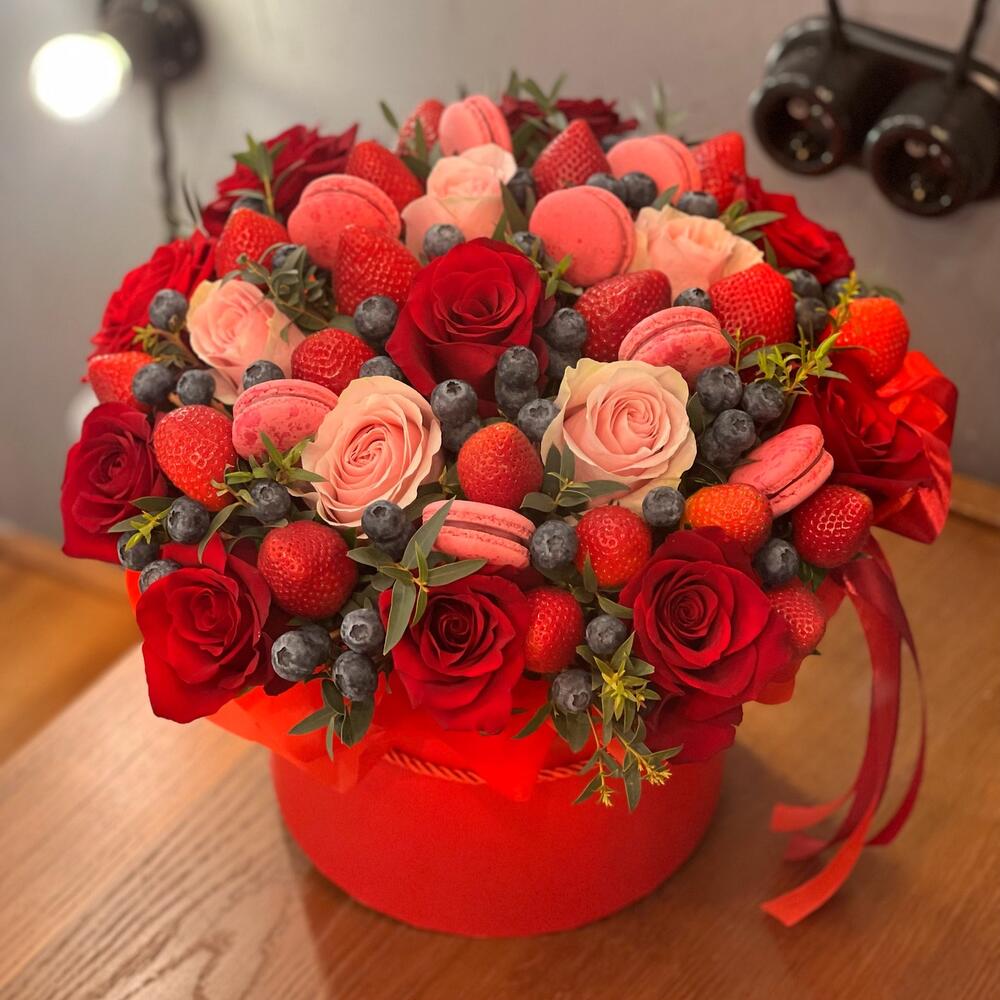 Цветы в коробке красные розы, клубника и пирожные макаронс
